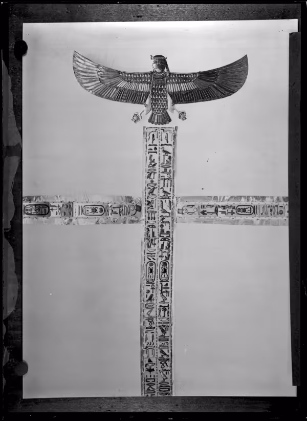 Image of golden bands and a human-headed bird with outstretched wings above negative
