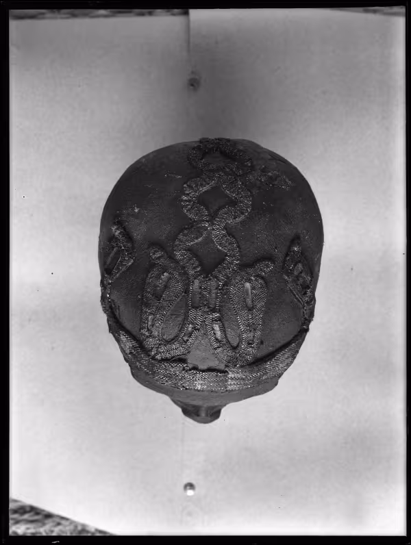 Image of negative of top of king's head disattached from mummy, showing beaded snake patterns
