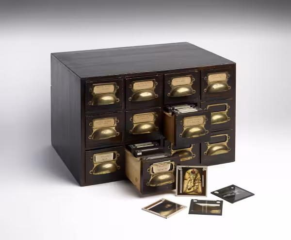 wooden chest of drawers with glass lantern slides