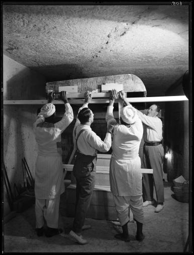 men lifting lid of shrine