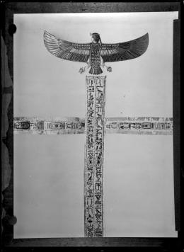 Image of golden bands and a human-headed bird with outstretched wings above negative