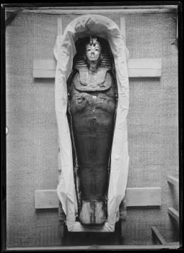 Image of king's mummy within coffin wearing gold mask