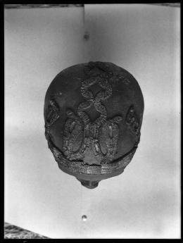 Image of negative of top of king's head disattached from mummy, showing beaded snake patterns