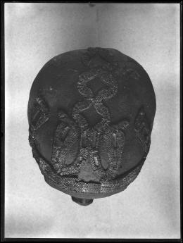 Image of negative of top of king's head disattached from mummy, showing beaded snake patterns