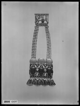 Image of negative of pectoral with triple scarab centrepiece with flowers below