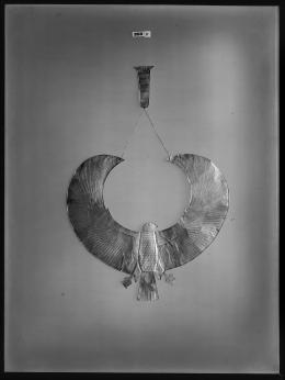 Image of negative of a flat gold falcon collar