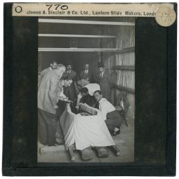 Image of lantern slide of people around open coffin