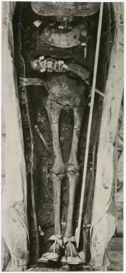 image of photographic print of lower part of king's unwrapped body within coffin in object card