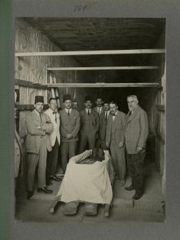 image of Carter and excavation team around coffin during the unwrapping, from Burton's album